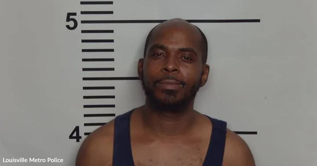Mugshot of a man standing before a height chart in a police booking photo.