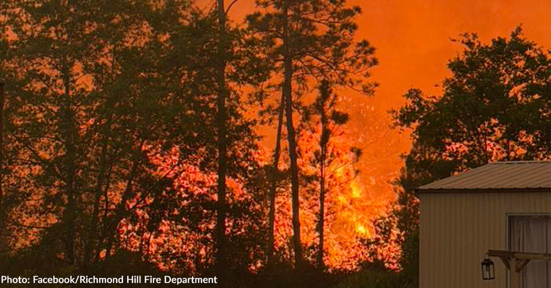 raging wildfire in forest surrounding home