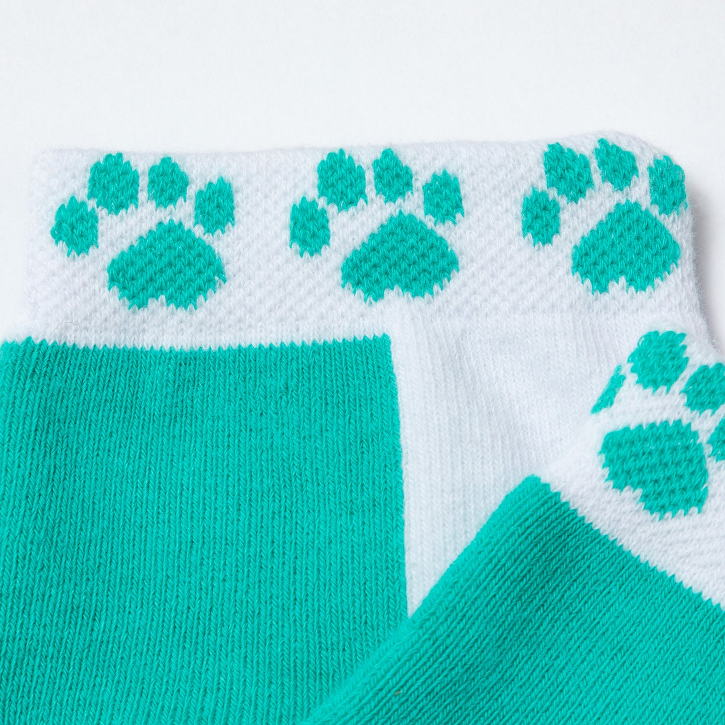 Close-up of the breathable fabric of the socks aqua and white paw sport ankle-length socks.