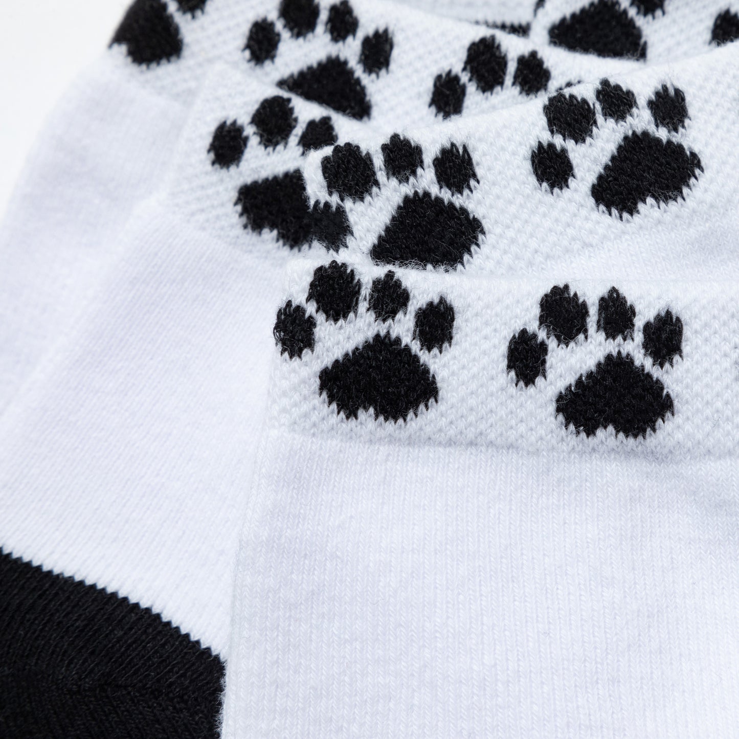 Close-up of the breathable material on the cuff of the sock as well as the black paw print design.