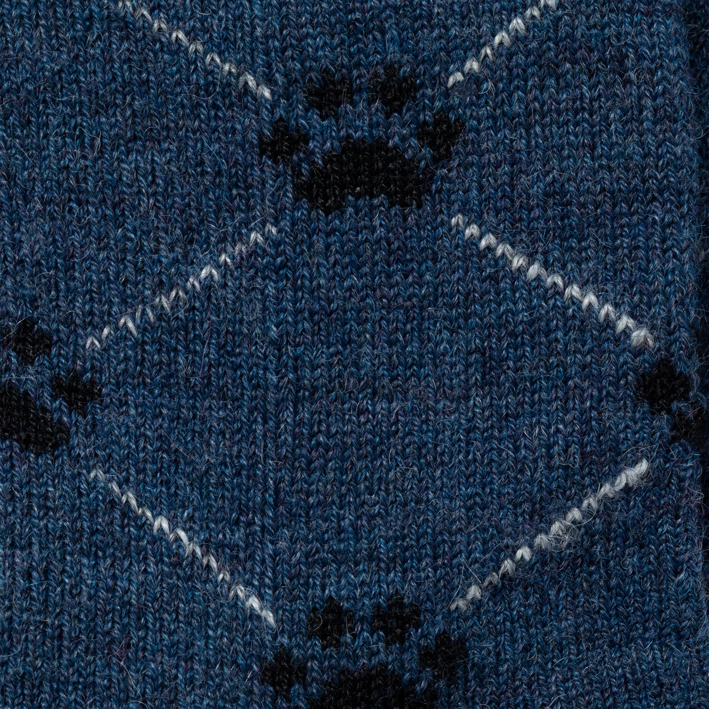 Close-up of blue fabric with black paw prints and white zigzag lines