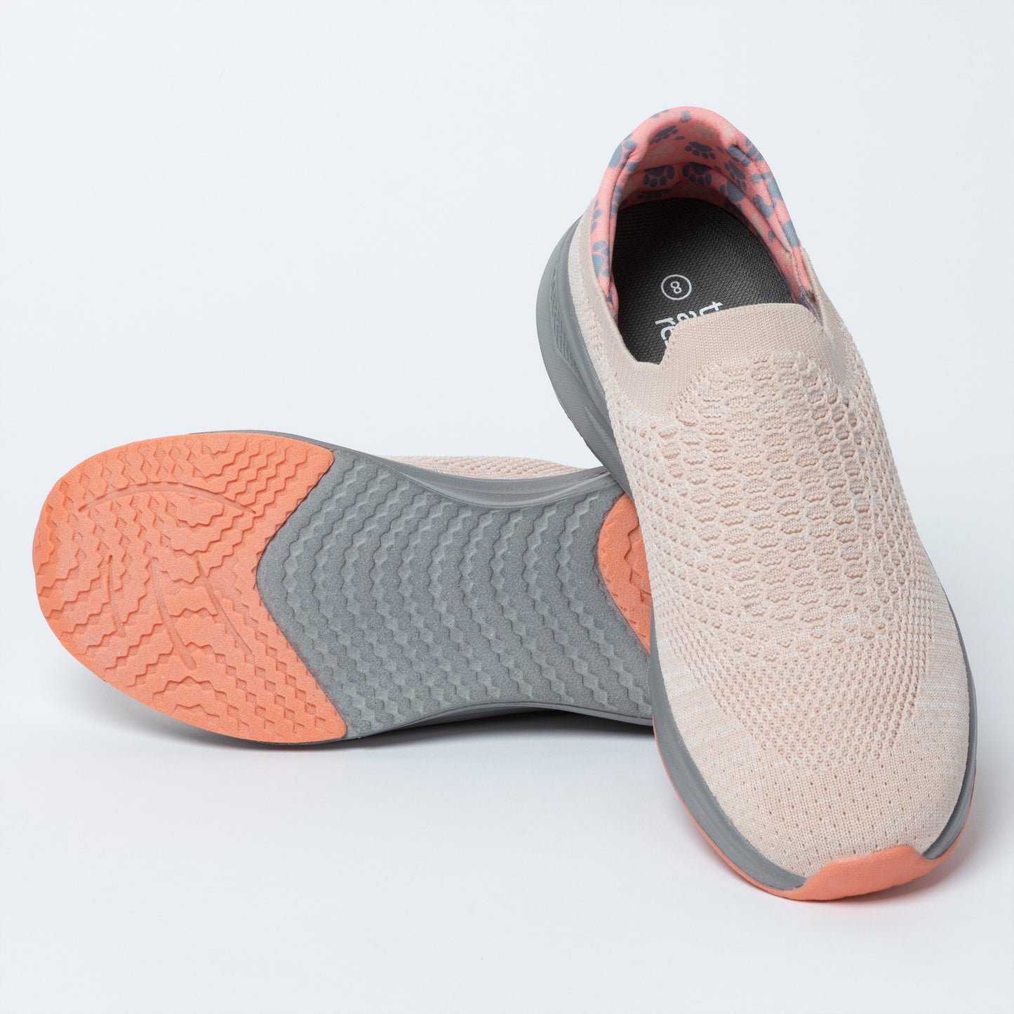 Light pink slip-on shoes with orange and gray soles on a white background