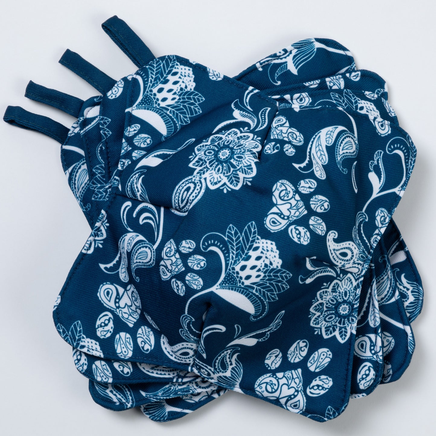 A set of four bowl cozies with various patterns, including a paw print design, blue paisley paws