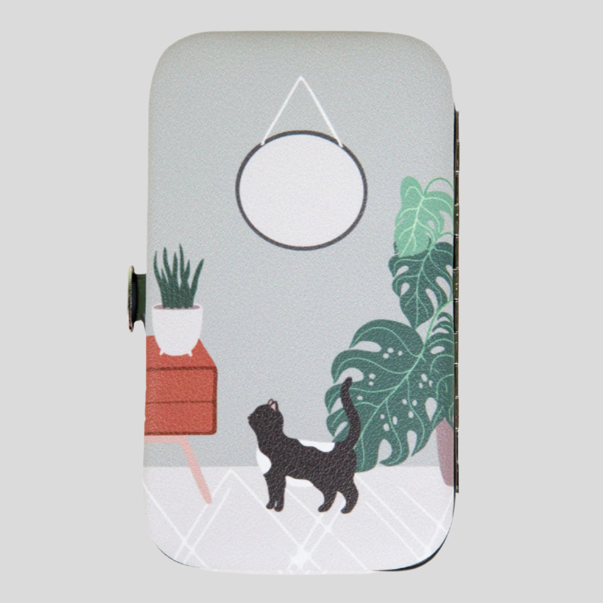 Illustration on a manicure kit of a black and white cat near houseplants and a round mirror.