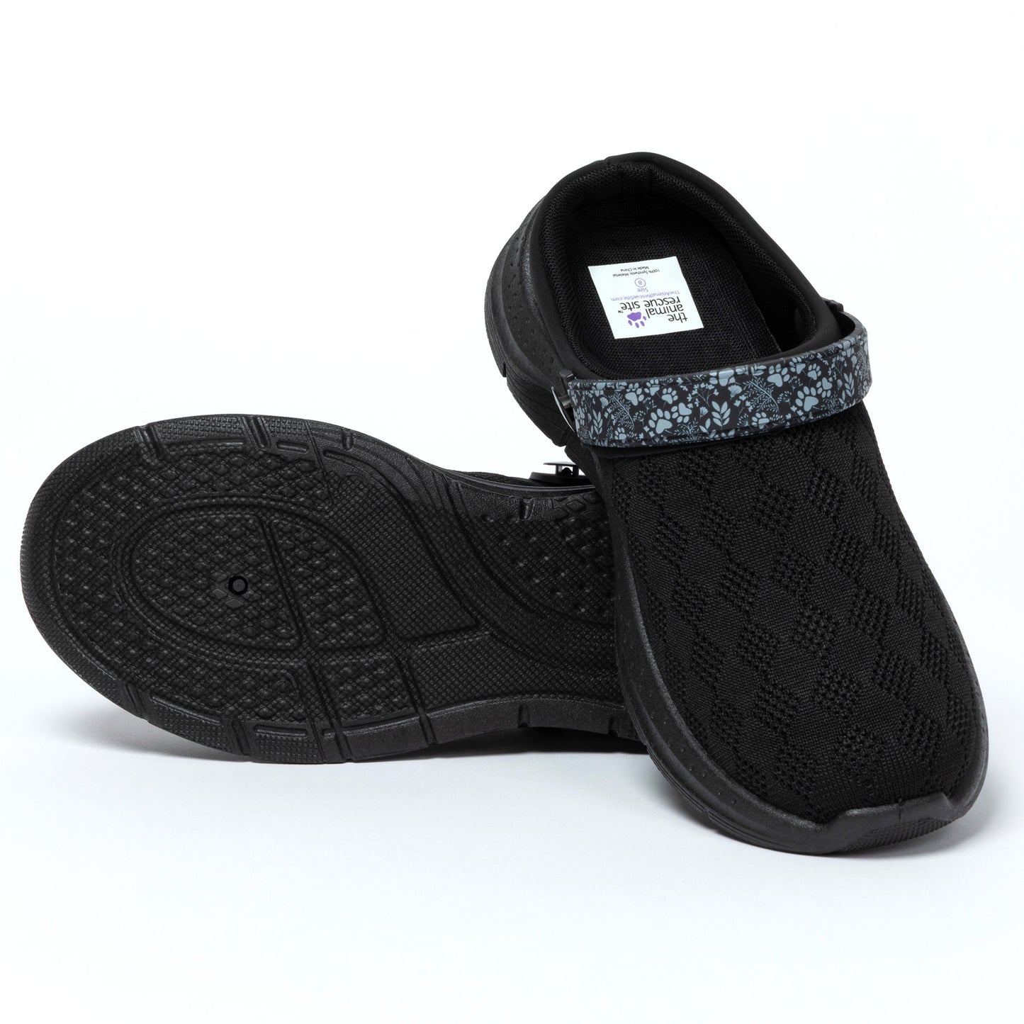 Black slip-on shoes with textured sole on a white background