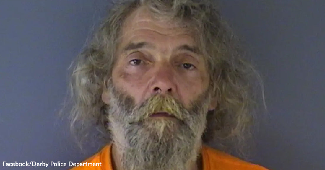 Mugshot of an older man with long gray hair and a beard wearing an orange shirt.