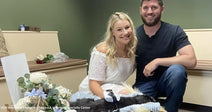 Couple smiling together with their pet in a cozy veterinary clinic setting.