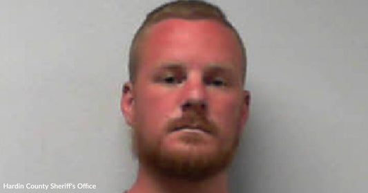 Mugshot of a red-bearded man against a plain light background.