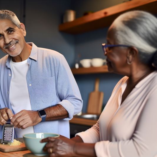 Two people smiling and cooking together in a kitchen.