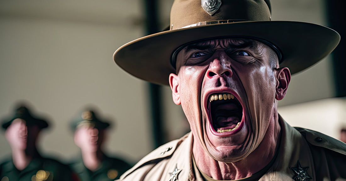 A drill instructor in a brown campaign hat screaming intensely during boot camp, with blurred recruits in the background.