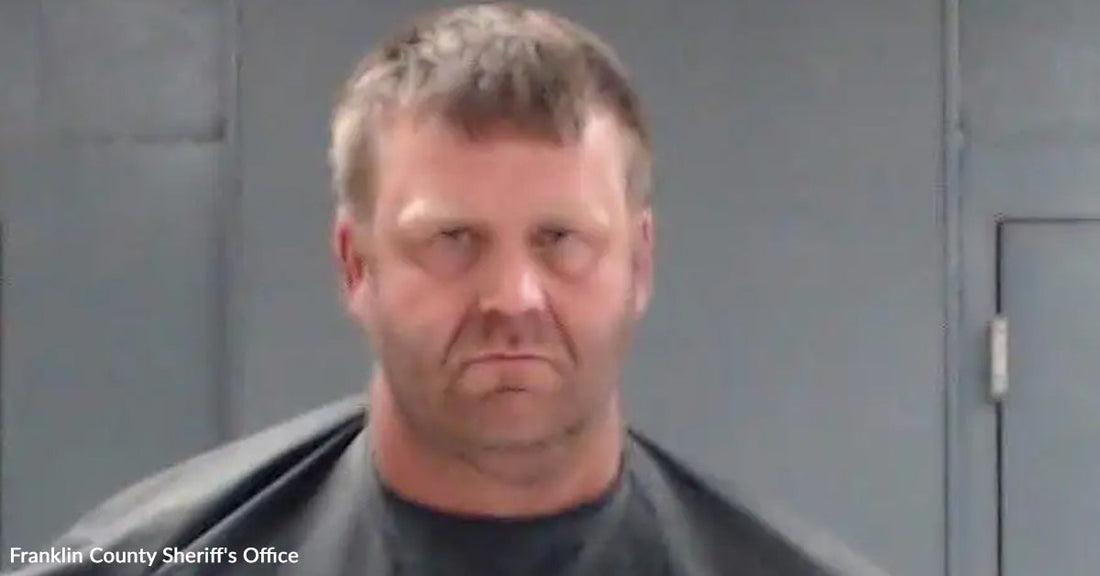 Mugshot-style photo of a man in front of a gray wall.