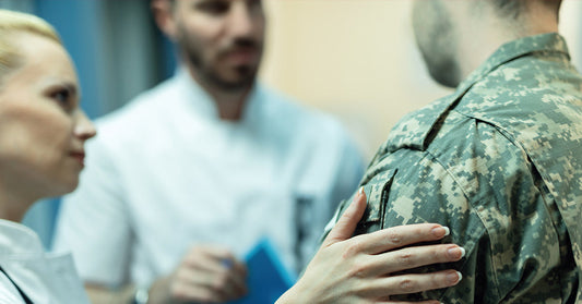 Medical professionals consult with a soldier in a healthcare setting.