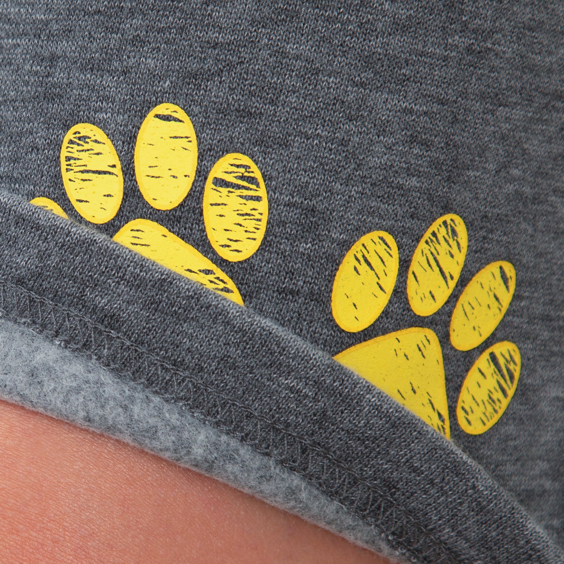 Gray board shorts with yellow paw prints on a close-up view