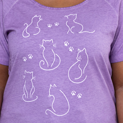Purple acid washed t-shirt with white cat illustrations and paw prints.