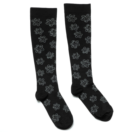 Black compression socks with white swirling paw prints on a white background.