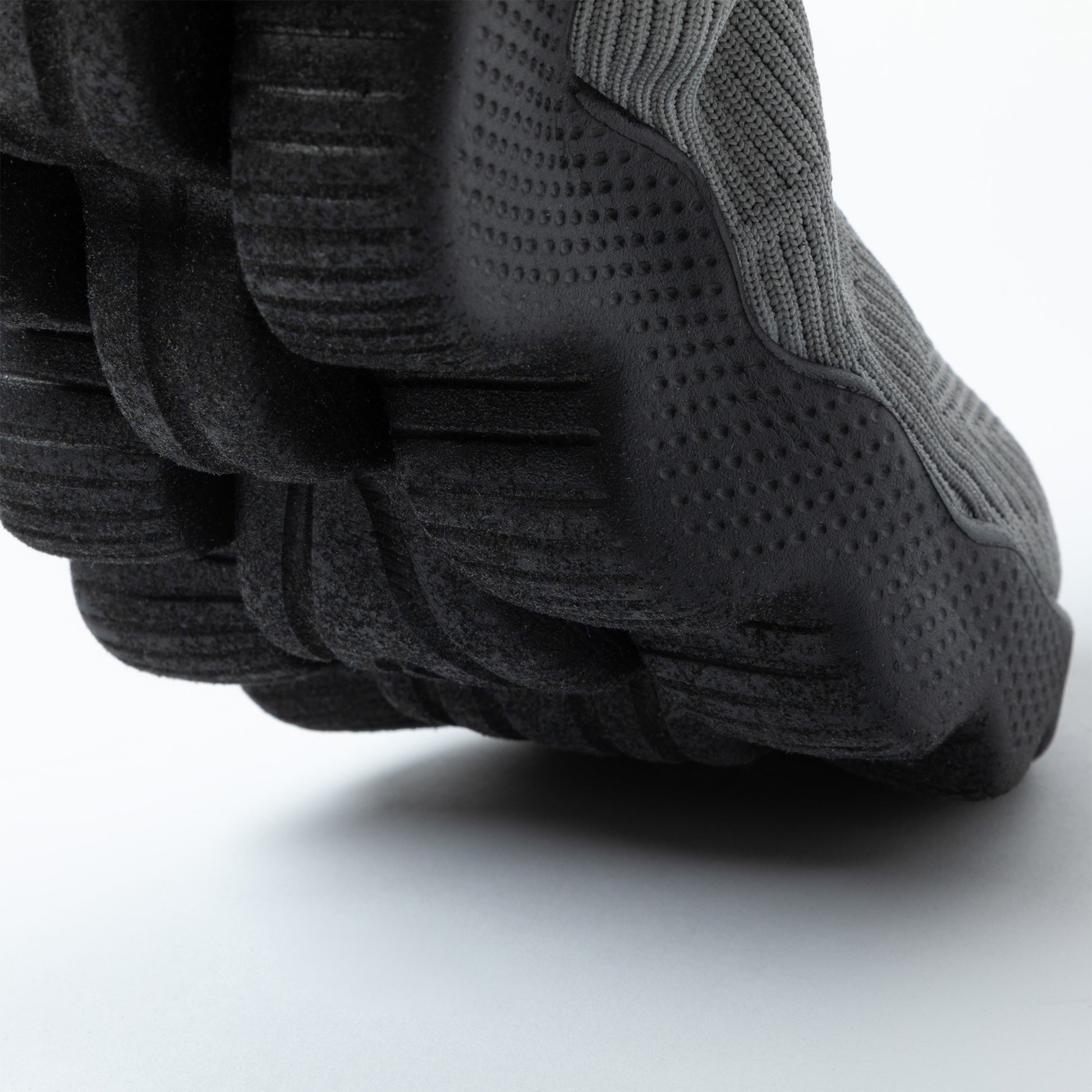 Close-up of a textured black outsole on a light gray background