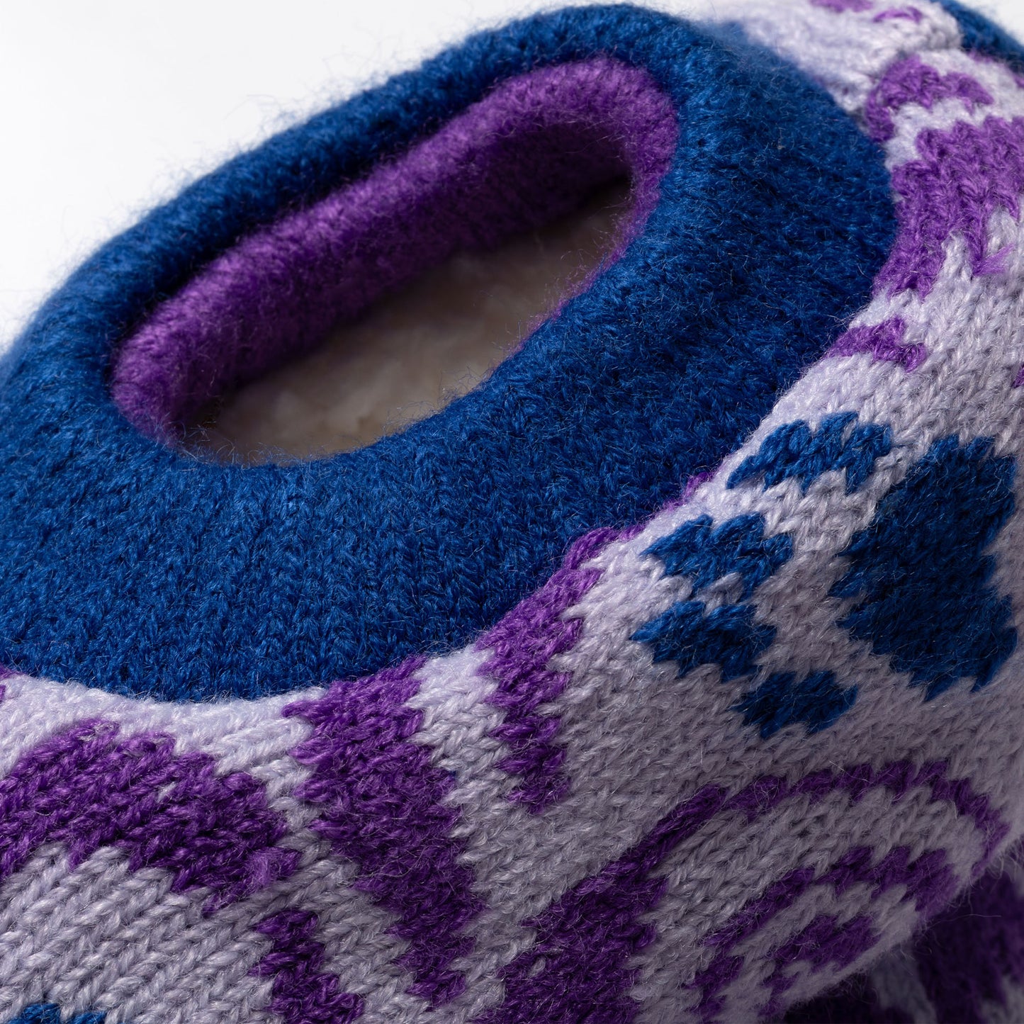 Close-up of a blue and purple knitted slipper sock cuff with a pattern, showing plush interior Paw Symphony