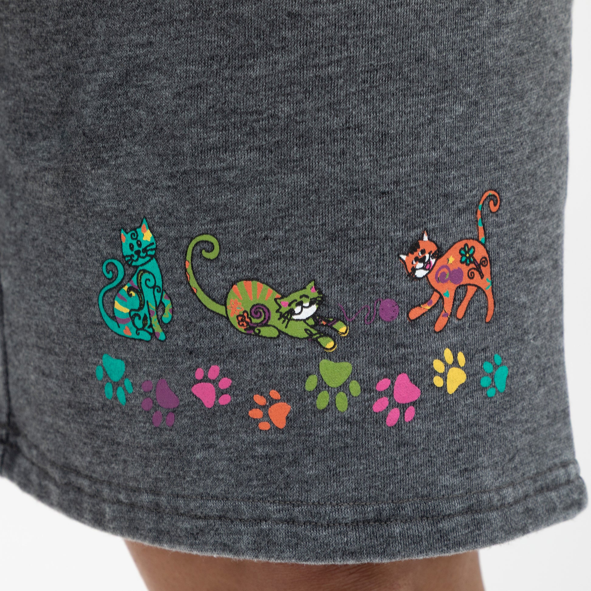Gray shorts with colorful cat designs and paw prints on a plain background