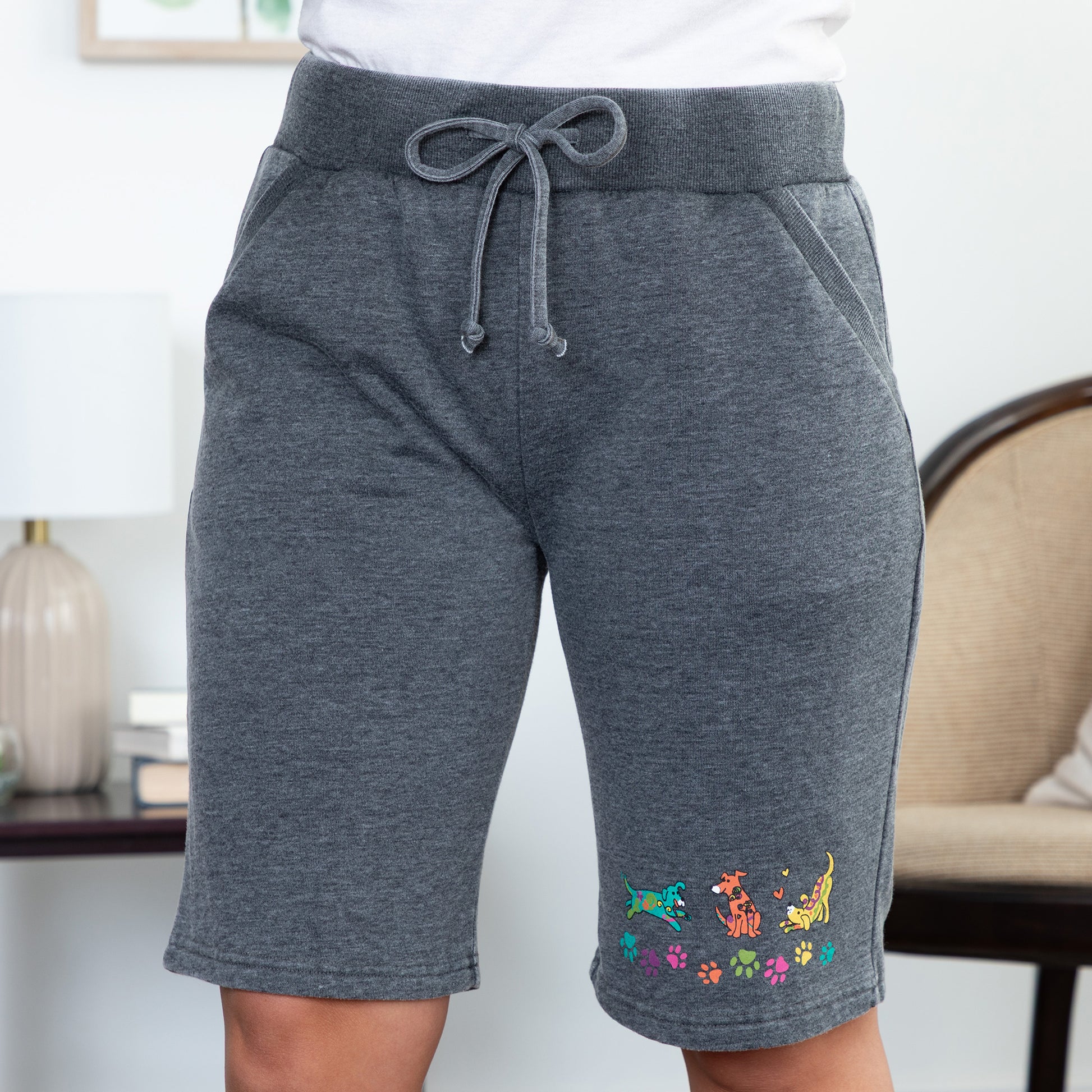 Gray shorts with colorful dog designs on a neutral background