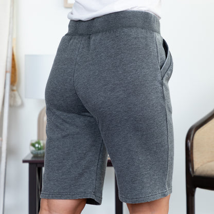 Person wearing gray shorts with a blurred indoor background