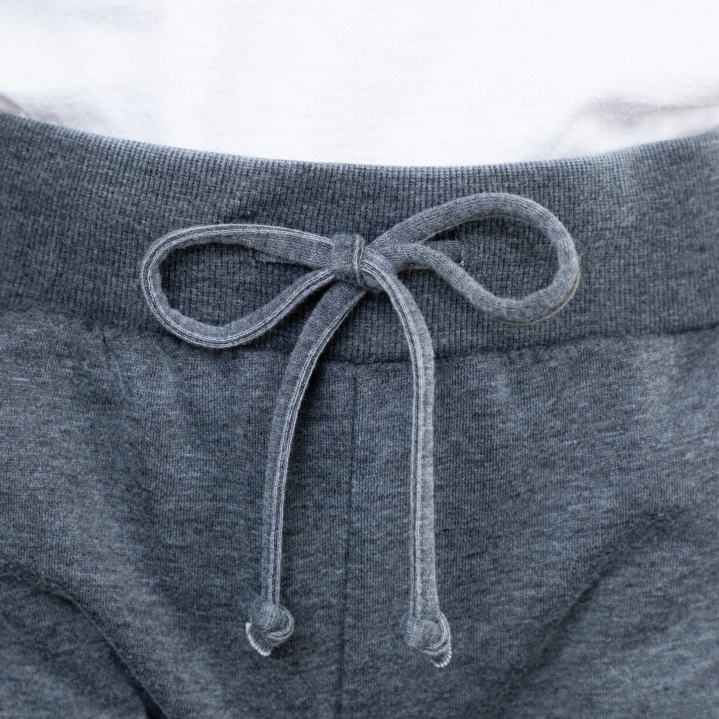 Close-up of gray sweatpants with a drawstring on a white background