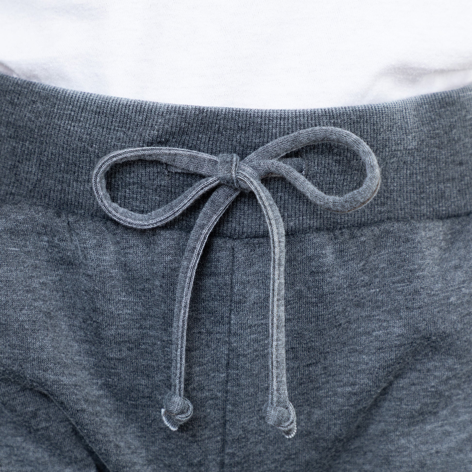 Close-up of gray sweatpants with a drawstring on a white background