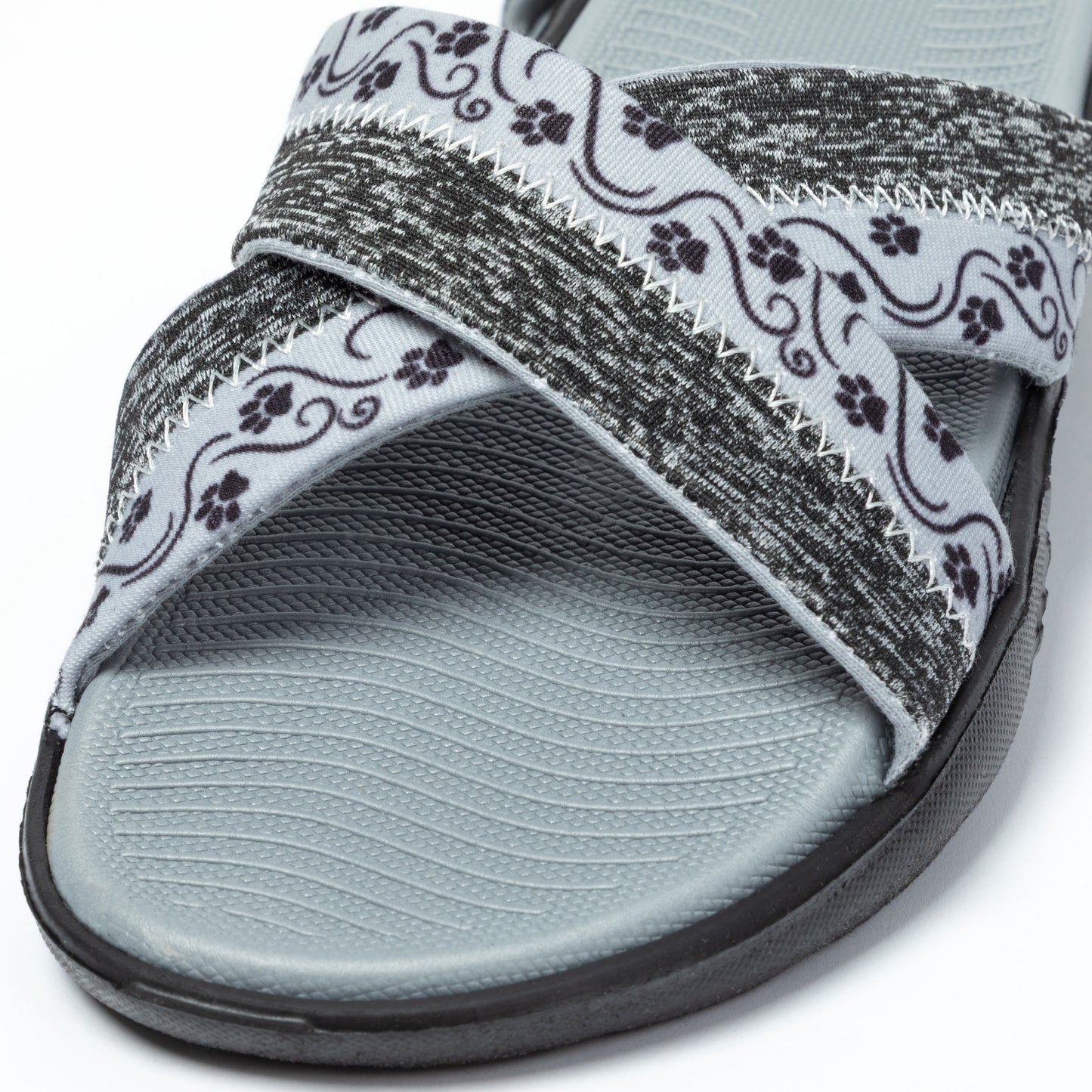 Gray slide sandal with patterned paw print strap on a white background
