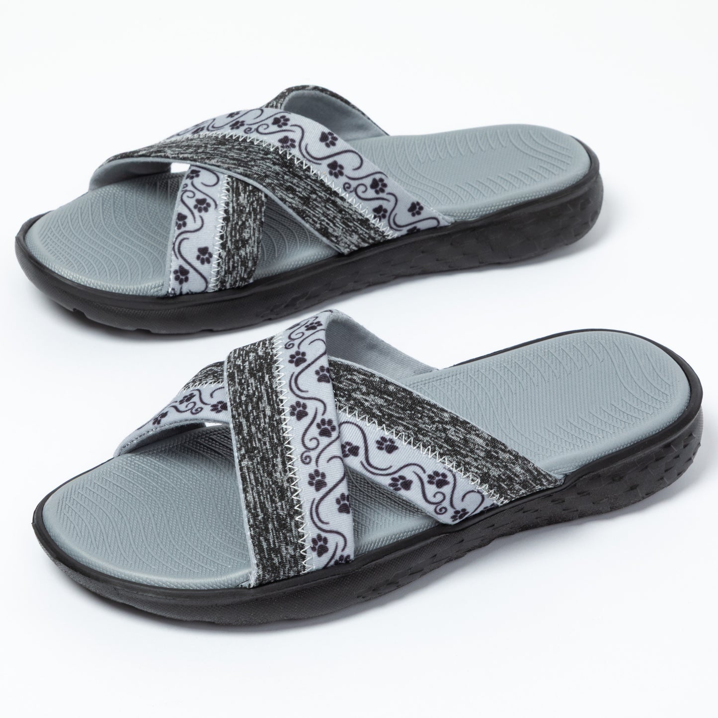 Pair of gray slides with paw patterned straps on a white background