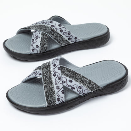 Pair of gray slides with paw patterned straps on a white background