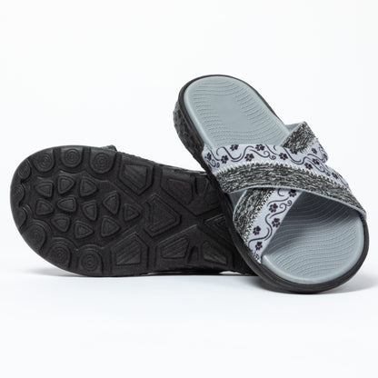 Gray slide sandals with paw patterned strap on a white background with a black traction sole