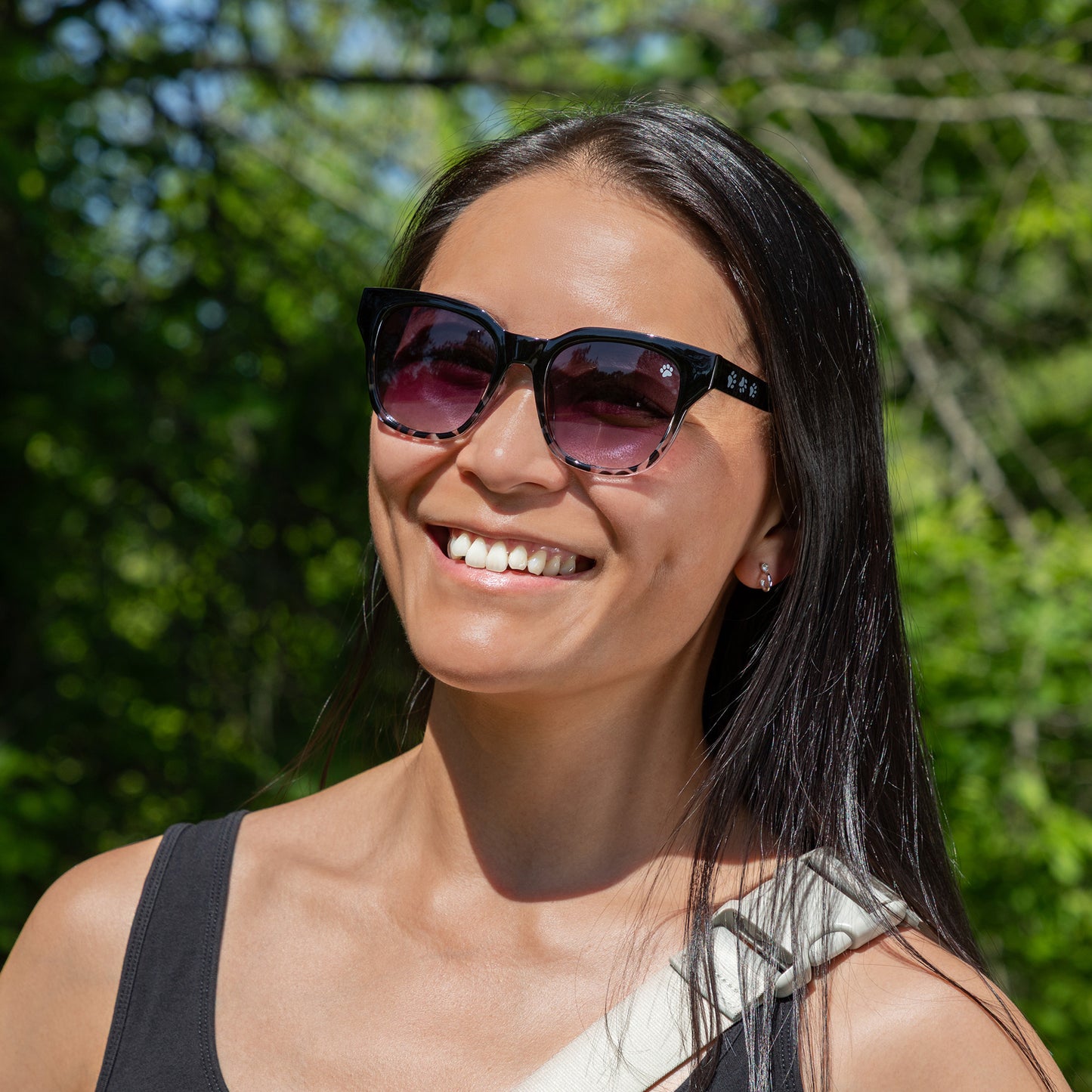 Woman wearing sunglasses with a blurred green background