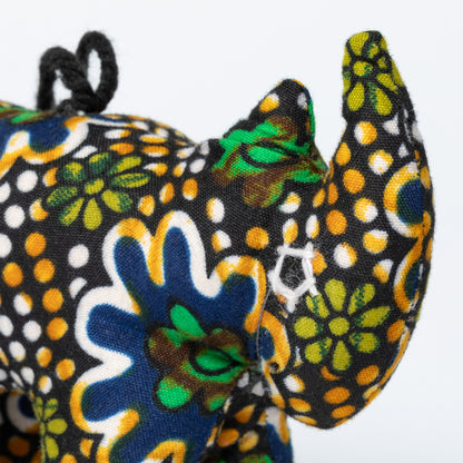 Colorful fabric rhino ornament with floral patterns on a white background.