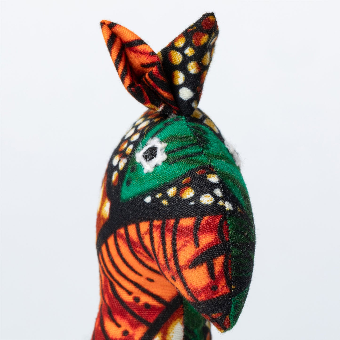 Colorful fabric giraffe ornament with intricate patterns on a white background