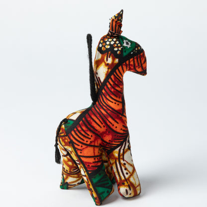 Colorful stuffed giraffe ornament on a white background.
