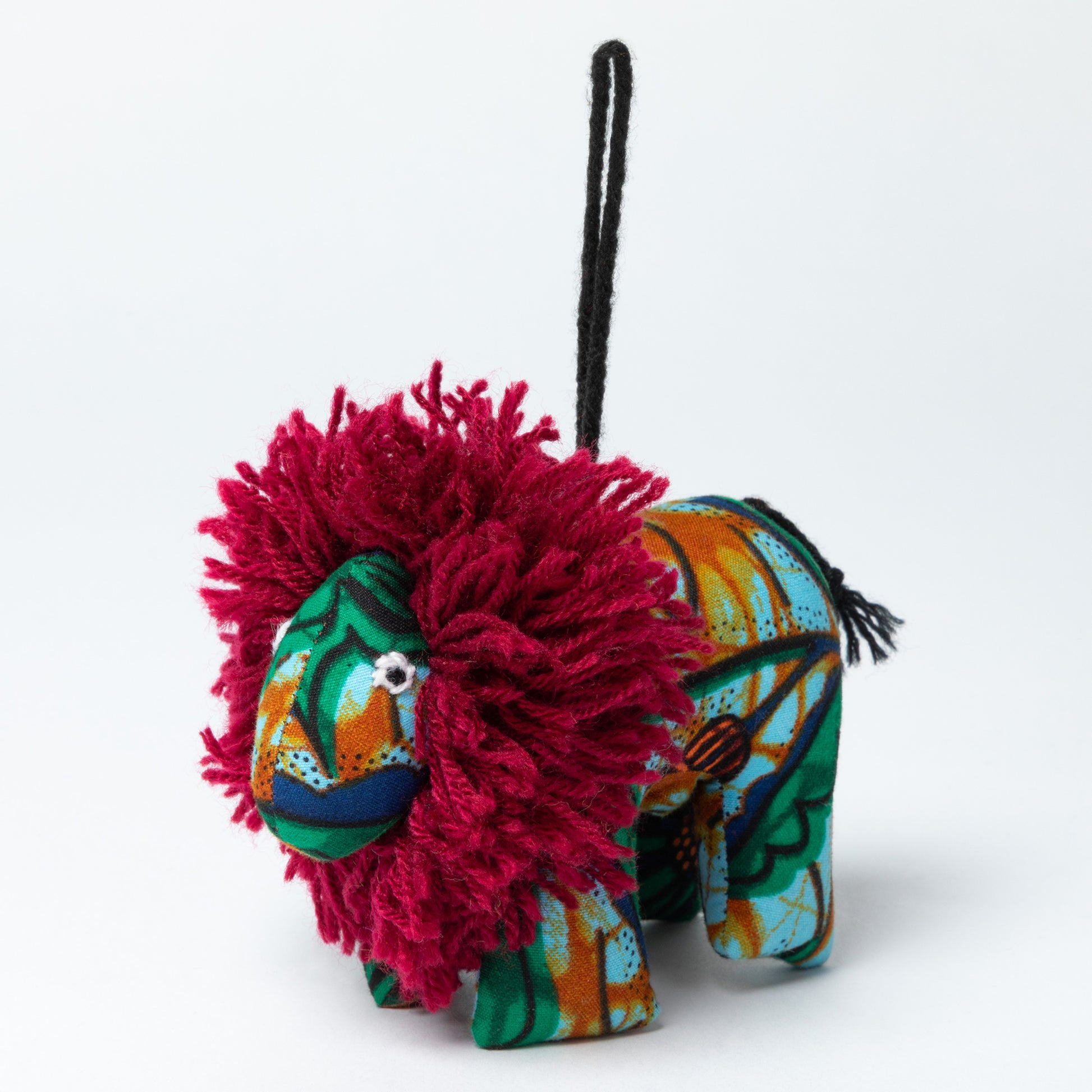 Colorful lion-shaped ornament with a fluffy red mane on a white background