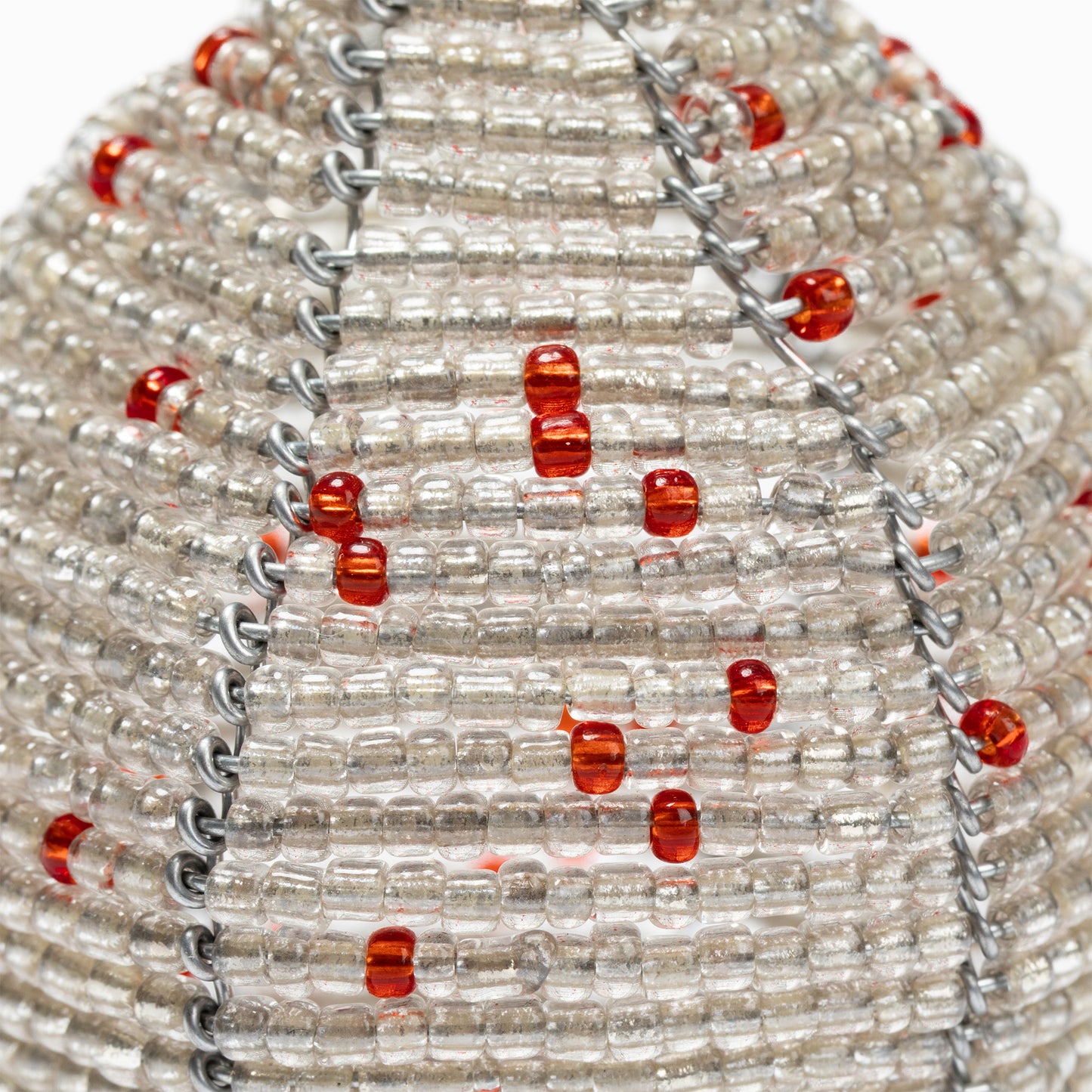 Close-up of a beaded necklace with red and clear beads on a white background
