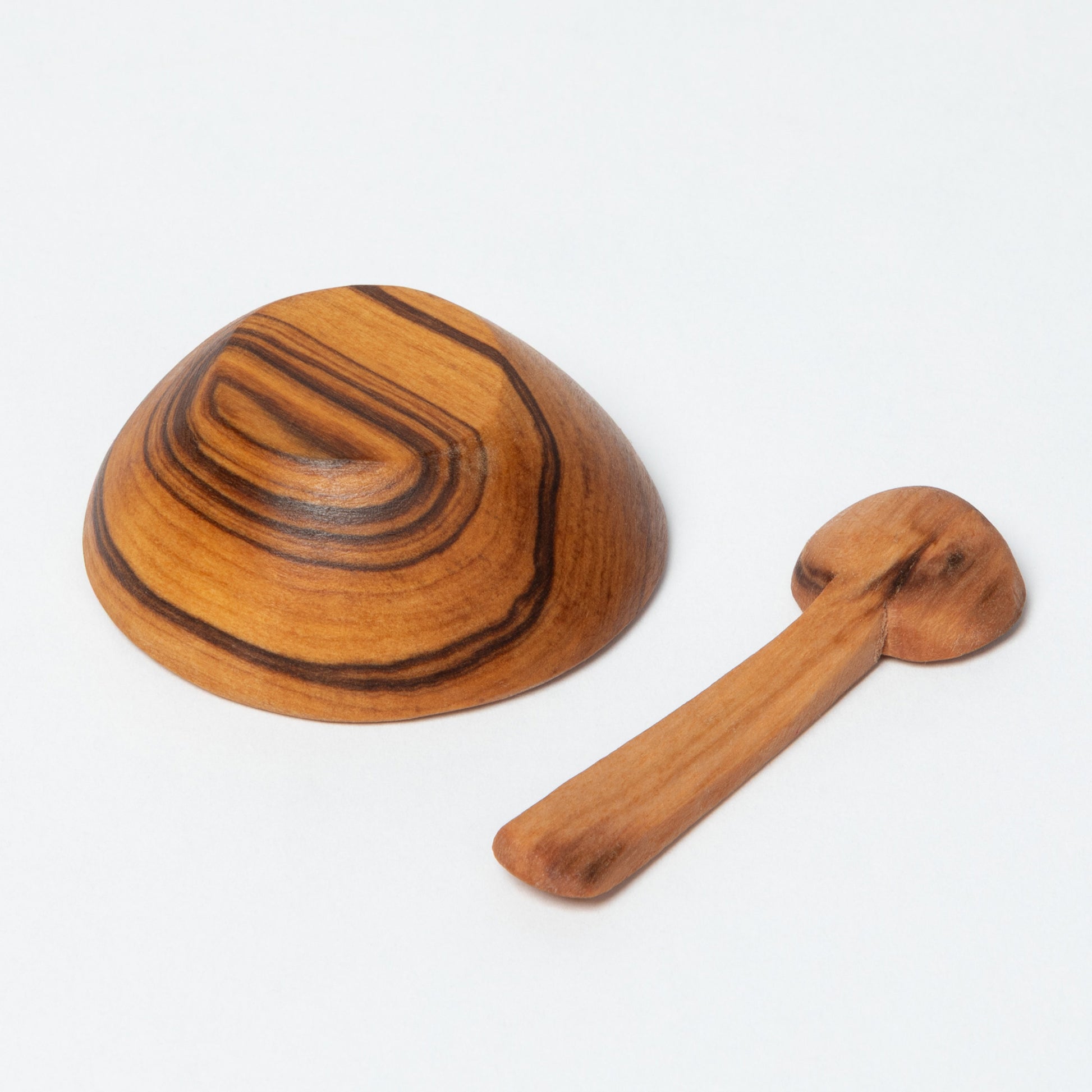 Wooden bowl and spoon turned upside down on a white background