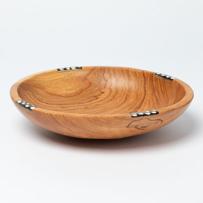 Wooden bowl with a decorative bone accent on a white background