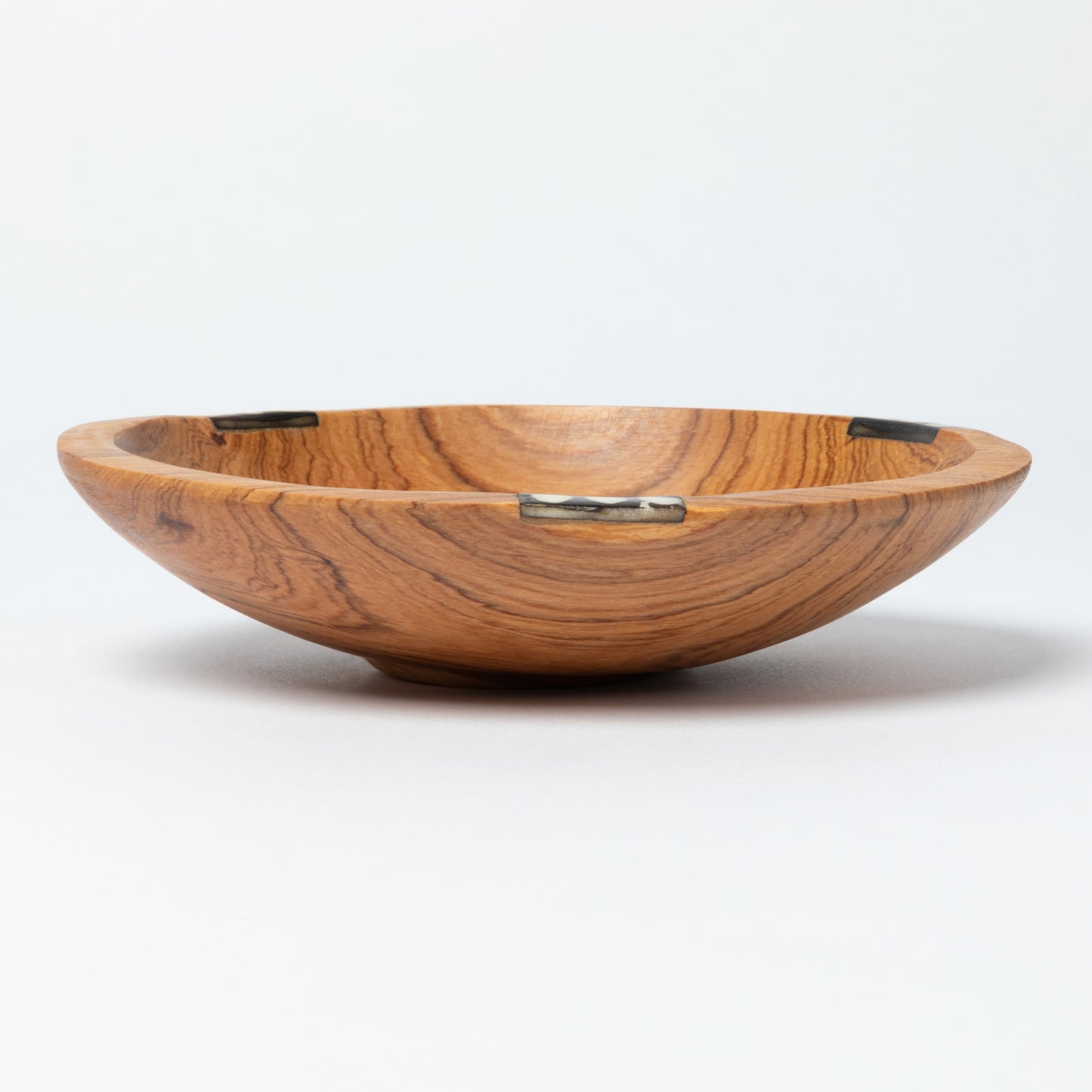 Wooden bowl with a decorative bone accent on a white background