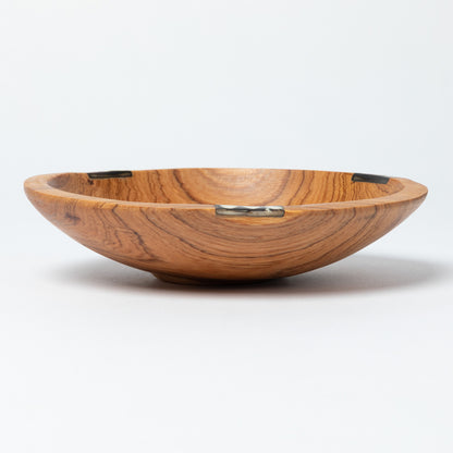 Wooden bowl with a decorative bone accent on a white background