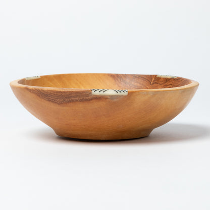 Wooden bowl with small bone inlay on a white background