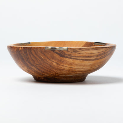 Wooden bowl with a decorative bone accent on a white background