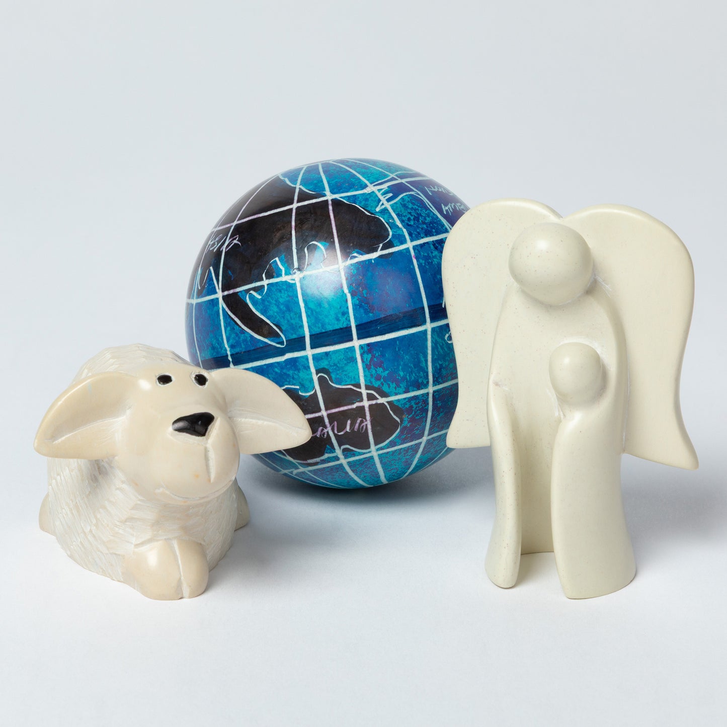 Two ceramic figures, one resembling a dog and the other an elephant, with a blue globe in the background.