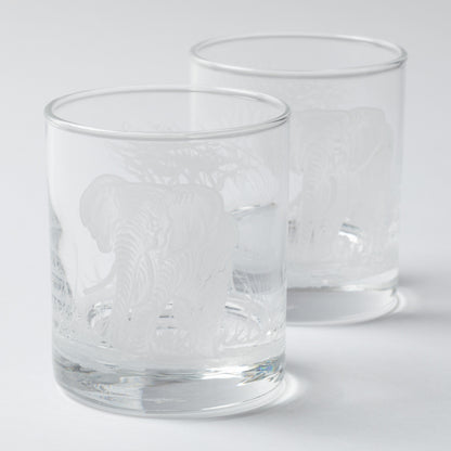Two clear glass tumblers with engraved designs on a white background