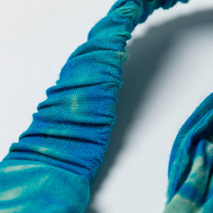 Close-up of a blue and green headband on a light gray background