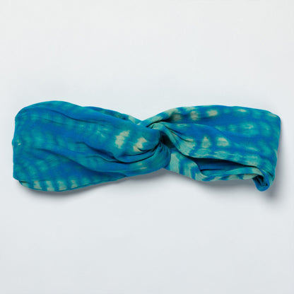 Blue and green patterned headband on a light gray background