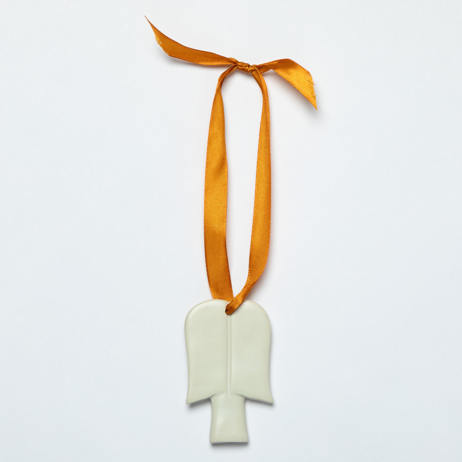 White soapstone angel ornament with a gold tone satin ribbon on a light gray background