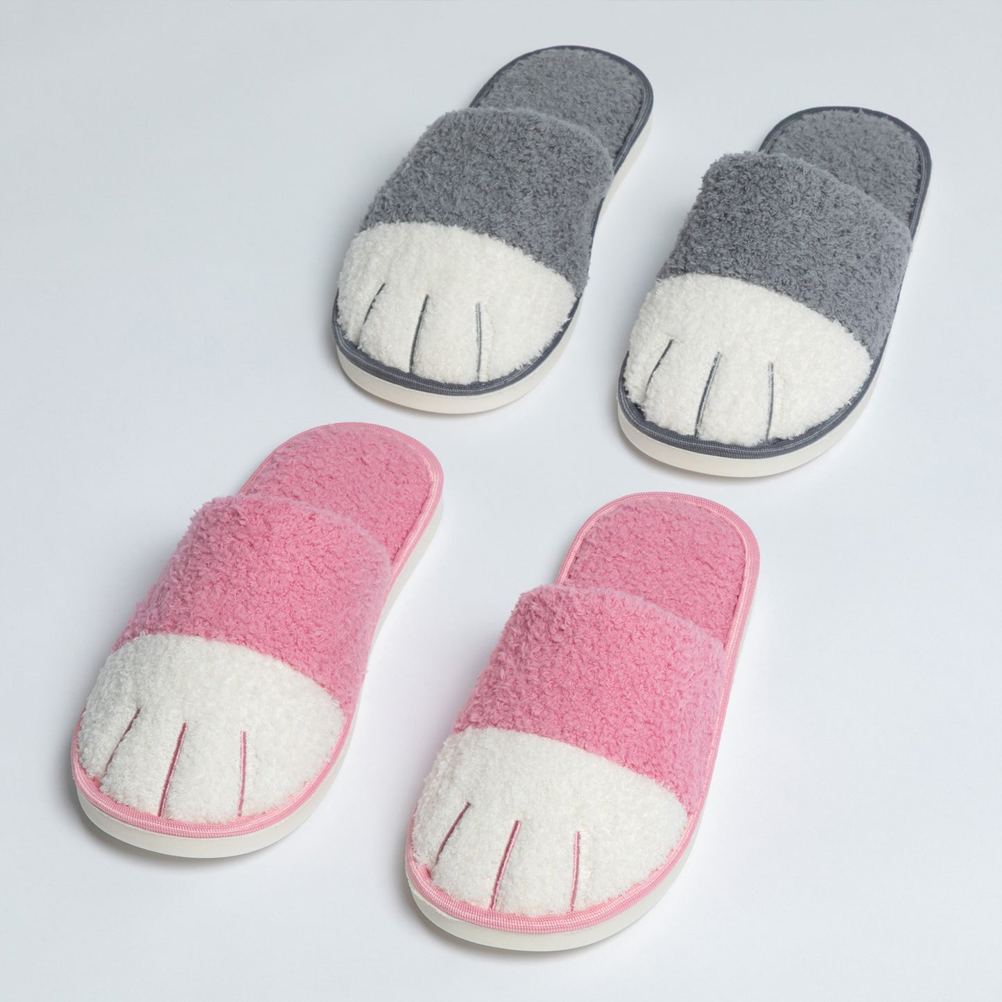 Pair of pink and gray slippers with a cat paw design on a light gray background