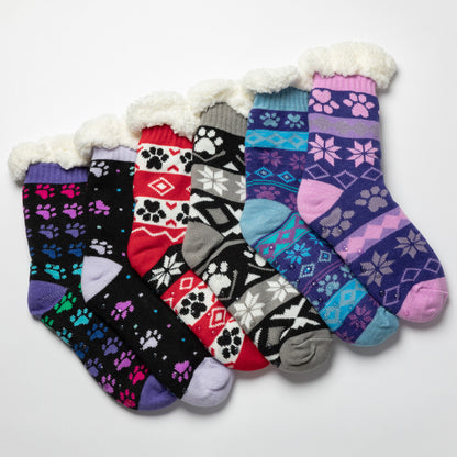 Set of colorful patterned sherpa lined cabine slipper socks with paw prints and snowflakes with traction dots on a white background