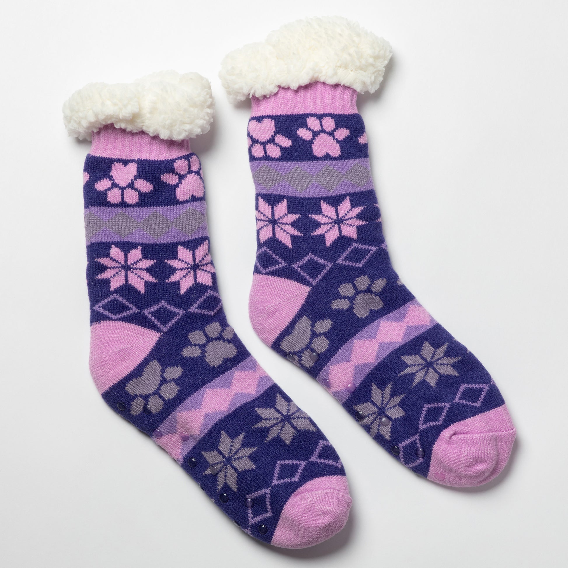 Pair of pink, gray purple Sherpa Fleece Lined Paw Print Cabin Slipper Socks with sherpa trim on a light gray background alpine fair isle paws plum